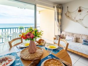 ein Esszimmer mit Tisch und Blick auf das Meer in der Unterkunft Apartment Les hauts de la corniche by Interhome in Mimizan-Plage + 28 Fotos