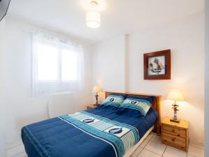ミミザン・プラージュにあるApartment Les Hauts de la Corniche by Interhomeのベッドルーム1室(青いシーツと窓付)