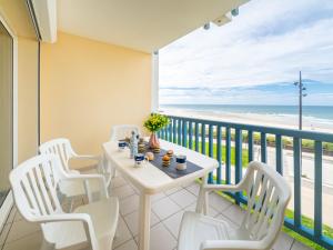 balcón con mesa y sillas y la playa en Apartment Les Hauts de la Corniche by Interhome, en Mimizan-Plage