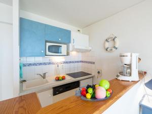 una cocina con un bol de fruta en una barra en Apartment Les Hauts de la Corniche by Interhome, en Mimizan-Plage