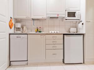 uma cozinha branca com armários e electrodomésticos brancos em Holiday Home Yllästar 1 as 208 - la-la by Interhome em Äkäslompolo
