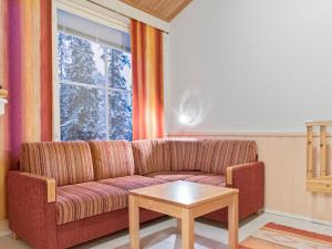 uma sala de estar com um sofá e uma mesa em Holiday Home Yllästar 1 as 208 - la-la by Interhome em Äkäslompolo