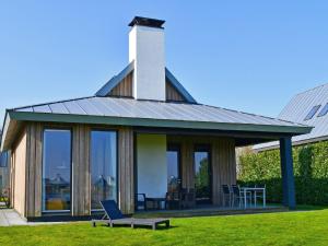 a house with glass doors and a table and chairs at Holiday Home Oesterdam Resort by Interhome in Tholen
