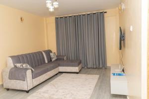 sala de estar con sofá y TV en Arabella Apartments en Bungoma