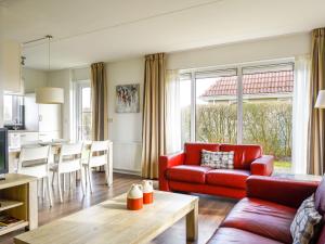 ein Wohnzimmer mit einem roten Sofa und einem Tisch in der Unterkunft Holiday Home Bungalowpark It Wiid by Interhome in Eernewoude
