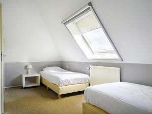 ein Schlafzimmer mit zwei Betten und einem Fenster in der Unterkunft Holiday Home Bungalowpark It Wiid by Interhome in Eernewoude + 9 Fotos