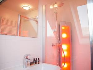 a bathroom with a shower with a sink and a mirror at Holiday Home Oesterdam Resort-1 by Interhome in Tholen