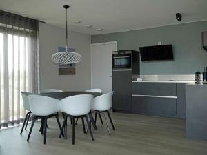 cocina y comedor con mesa y sillas en Holiday Home Oesterdam Resort by Interhome en Tholen