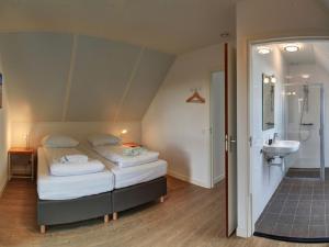 1 dormitorio con 1 cama y baño con lavamanos en Holiday Home Oesterdam Resort by Interhome en Tholen