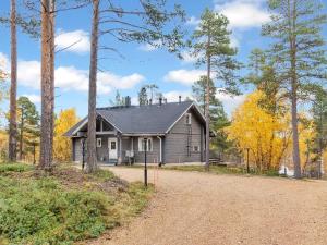 a house in the woods with a gravel road at Holiday Home Peurakumpu by Interhome in Ivalo +23 photos