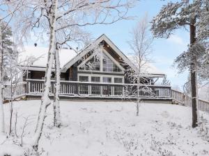 a house with a deck in the snow at Holiday Home Peurakumpu by Interhome in Ivalo