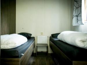 duas camas num pequeno quarto com esta descrição em Holiday Home Duinhoeve-1 by Interhome em Udenhout