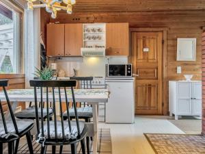 Il comprend une cuisine équipée d'un réfrigérateur blanc et d'une table avec des chaises. dans l'établissement Holiday Home Ruokovirran mökki by Interhome, à Siilinjärvi