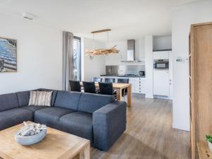 een woonkamer met een bank en een tafel bij Holiday Home Oesterdam Resort-1 in Tholen