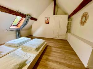 a bedroom with two beds in a attic at villa festive HOMAZING piscine privée 2h de Paris in Choué