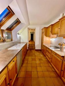 a kitchen with wooden cabinets and a tile floor at villa festive HOMAZING piscine privée 2h de Paris in Choué
