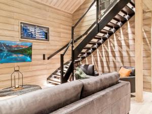 a living room with a couch and stairs at Holiday Home Hankielämä b by Interhome in Sirkka