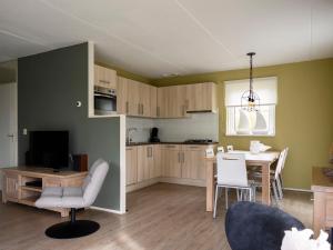 a living room with a kitchen and a dining room at Holiday Home Bungalowpark It Wiid in Eernewoude