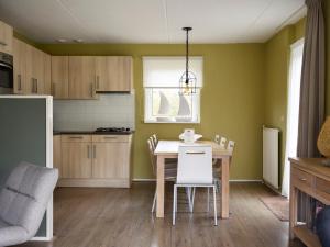 eine Küche mit Tisch und Stühlen in einem Zimmer in der Unterkunft Holiday Home Bungalowpark It Wiid by Interhome in Eernewoude + 17 Fotos