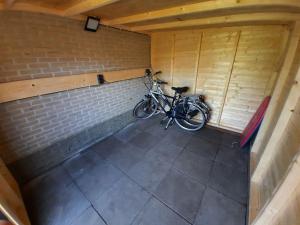 a bike parked in a room with a brick wall at Holiday Home Bungalowpark It Wiid in Eernewoude