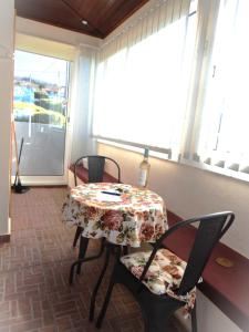 a table and chairs with a table and a window at Jasmine Guest Suite in Ponta do Pargo