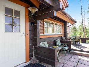 a house with a porch with chairs and a door at Holiday Home Villa virkeä by Interhome in Vierumäki