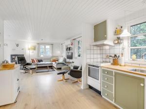 a kitchen and living room with a table and chairs at Holiday Home Calle - 1km from the sea in Western Jutland by Interhome in Vejers Strand