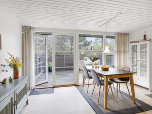 a kitchen with a dining room table and chairs at Holiday Home Calle - 1km from the sea in Western Jutland by Interhome in Vejers Strand