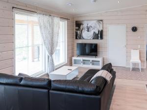 a living room with a leather couch and a tv at Holiday Home Saana 4 by Interhome in Kilpisjärvi