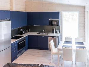 a kitchen with blue cabinets and a table with chairs at Holiday Home Saana 4 by Interhome in Kilpisjärvi