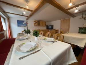 uma mesa com placas brancas e talheres em Holiday Home Zentral - PET211 by Interhome em Pettneu am Arlberg