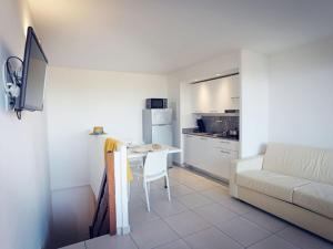 モリアニ・プラージュにあるApartment MB4 Loggia - MNI106 by Interhomeのリビングルーム(ソファ、テーブル付)、キッチンが備わります。