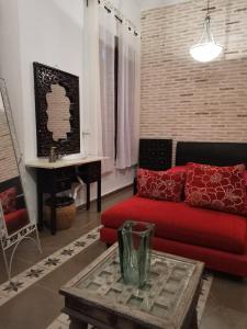 a living room with a red couch and a table at Rincones con encanto in Cartagena