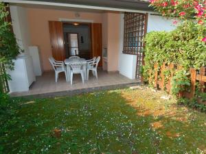 eine Terrasse mit Stühlen und einem Tisch in einem Haus in der Unterkunft Holiday Home Mediterraneo-2 by Interhome in Rosolina Mare