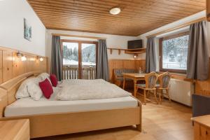 a bedroom with a bed and a table and chairs at Winklhütte in Forstau
