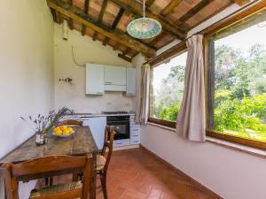 a kitchen with a table and two windows at Apartment Rosmarino by Interhome in Sorano