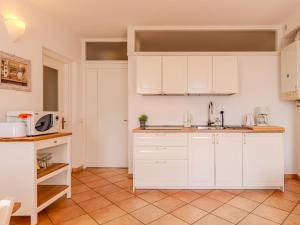 a kitchen with white cabinets and a tile floor at Apartment La Pianca-4 by Interhome in Musso