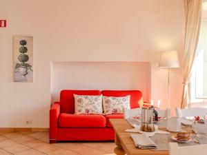 a living room with a red couch and a table at Apartment La Pianca-4 by Interhome in Musso