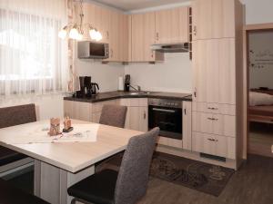 a kitchen with a table and chairs in a room at Apartment Daheim – Edelweiß - PZT382 by Interhome in Plangeross