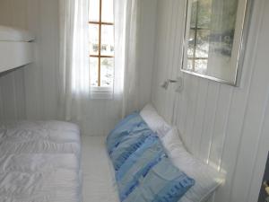 a white room with a bed and a window at Chalet Thorabu - SOW117 by Interhome in Øyuvstad