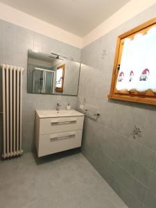 a bathroom with a sink and a mirror at Collalto Guest House in Piancavallo