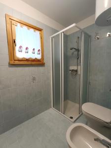 e bagno con doccia, servizi igienici e lavandino. di Collalto Guest House a Piancavallo