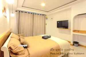1 dormitorio con 1 cama y TV en la pared en MeeJai Pool View Kohlarn, en Koh Larn