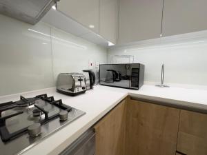 eine Küche mit einem Herd und einer Mikrowelle in der Unterkunft Beautifull 3 Bedroom @ Al Raha Beach in Abu Dhabi