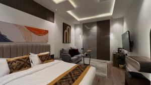 um quarto com uma cama, uma cadeira e uma televisão em استديو حطين أنيق مقابل البوليفارد مدخل خاص em Riyadh