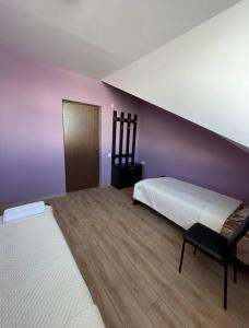 1 dormitorio con 2 camas y pared púrpura en Khando2023, en Gudauri