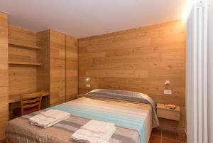 1 dormitorio con 1 cama con paredes de madera en Bel Sass en Piuro