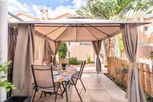 - une table et des chaises sous un parasol sur la terrasse dans l'établissement Bungalow Green Oasis Club, à Maspalomas