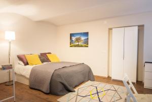 ブレッドにあるCastle Rock Bled apartmentのベッドルーム1室(ベッド1台付)が備わります。壁には絵画が飾られています。