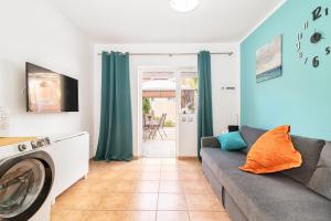 a living room with a couch and a washing machine at Bungalow Green Oasis Club in Maspalomas